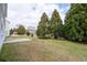 Large grassy backyard lined with mature trees and a concrete patio at 4728 Sedum Way, Atlanta, GA 30349