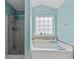 Bright bathroom featuring a soaking tub, tiled backsplash, and glass enclosed shower at 4728 Sedum Way, Atlanta, GA 30349