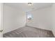 A bright bedroom featuring neutral walls, soft grey carpet, and a sunlit window at 4728 Sedum Way, Atlanta, GA 30349
