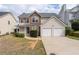 Inviting front of house with stone details, attached two car garage and manicured landscaping at 4728 Sedum Way, Atlanta, GA 30349