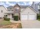 Two-story home featuring stone accents, vinyl siding, a two-car garage, and a cozy front porch at 4728 Sedum Way, Atlanta, GA 30349