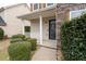 Charming covered front porch with white railing and black front door, framed by lush greenery at 4728 Sedum Way, Atlanta, GA 30349