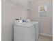 A well-lit laundry room featuring white appliances, shelving and vinyl flooring at 4728 Sedum Way, Atlanta, GA 30349