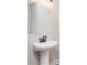 A pedestal sink with dark fixtures and a large mirror in a well lit neutral colored powder room at 30 Sportsman Path, Dallas, GA 30157