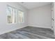 Bedroom featuring gray hardwood flooring, white trim, two bright windows, and neutral walls at 30 Sportsman Path, Dallas, GA 30157