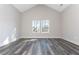 A bright bedroom with a vaulted ceiling, grey wood-look flooring, and two windows at 30 Sportsman Path, Dallas, GA 30157