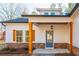 Covered front porch featuring stacked stone, wood columns, a blue door, and a hanging lantern at 30 Sportsman Path, Dallas, GA 30157