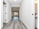 Hallway with neutral walls leading to a room with an overhead fan, gray flooring, and bathroom at 30 Sportsman Path, Dallas, GA 30157