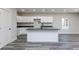 Modern kitchen featuring white cabinets, dark countertops, a kitchen island and stainless steel appliances at 30 Sportsman Path, Dallas, GA 30157