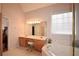 Bright bathroom featuring a tiled soaking tub, large window, and vanity with double sinks at 3405 Lake Valley Way, Douglasville, GA 30135