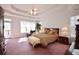 Spacious main bedroom with a tray ceiling, large windows, and doorway to a private deck at 3405 Lake Valley Way, Douglasville, GA 30135