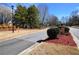 Street view of Greythorne entrance with brick sign and trimmed bushes and landscaped ground cover at 3405 Lake Valley Way, Douglasville, GA 30135