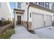 Townhome entrance showcasing a two-car garage, stone accents, and a welcoming front door for a cozy feel at 3545 Bexton Dr, Duluth, GA 30097