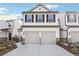 Charming townhome featuring a two-car garage, white siding, and black shutters, offering modern curb appeal at 3545 Bexton Dr, Duluth, GA 30097