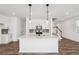 Bright kitchen featuring a central island with seating, white cabinetry, and modern pendant lighting at 3545 Bexton Dr, Duluth, GA 30097