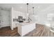 Modern kitchen with a large island, white cabinets, stainless steel appliances, and stylish pendant lighting at 3545 Bexton Dr, Duluth, GA 30097