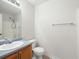 Bathroom featuring single sink vanity, mirror, toilet and a tiled shower behind a glass door at 169 Bethnal Way, Douglasville, GA 30134
