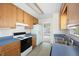 Bright kitchen with wooden cabinets, stainless steel sink, and view into dining room at 169 Bethnal Way, Douglasville, GA 30134