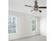 Bedroom with ceiling fan, carpet flooring, and windows overlooking a treed backyard at 169 Bethnal Way, Douglasville, GA 30134