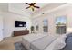 The main bedroom has neutral carpet, bright white walls, TV, ceiling fan, and many windows at 2428 Crescent Park Ct, Atlanta, GA 30339