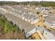 Aerial view of a community of modern townhomes with neat landscaping and street parking at 685 Stickley Oak Way, Woodstock, GA 30189