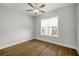 This bedroom features wood floors, a ceiling fan, and a window for ample natural light and comfort at 685 Stickley Oak Way, Woodstock, GA 30189
