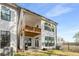 The rear exterior of a white townhome with a wood balcony and a grill on the patio at 685 Stickley Oak Way, Woodstock, GA 30189