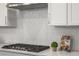 Gas range, herringbone backsplash and white cabinets in this modern kitchen at 685 Stickley Oak Way, Woodstock, GA 30189