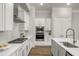 Beautiful kitchen featuring white cabinets, stainless steel appliances, backsplash, and an island with sink at 685 Stickley Oak Way, Woodstock, GA 30189