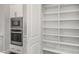 Open shelving in pantry with white walls, a microwave, and an oven at 685 Stickley Oak Way, Woodstock, GA 30189