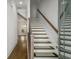 A staircase with hardwood steps, wooden handrail, and natural light streaming from the doorway at 685 Stickley Oak Way, Woodstock, GA 30189