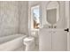 Modern bathroom features sleek white vanity, and bathtub with gray accent tile at 115 Arcadia Ave, Fayetteville, GA 30214