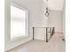 Upstairs hallway with railings, chandelier, and natural light from the window at 115 Arcadia Ave, Fayetteville, GA 30214