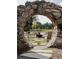 Seating area with unique outdoor fireplace, viewed through a stone archway at 115 Arcadia Ave, Fayetteville, GA 30214