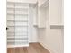 Walk-in closet with custom white shelving and hanging racks at 115 Arcadia Ave, Fayetteville, GA 30214