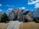 Beautiful exterior with a stone facade, manicured lawn, and a spacious multi-car driveway at 1205 Trey Ct, Marietta, GA 30064