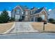 Charming exterior featuring professional landscaping, a multi-car garage, and a circular driveway at 1205 Trey Ct, Marietta, GA 30064