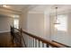 Upstairs hallway featuring wood floors and a decorative light fixture, leading to various rooms at 1205 Trey Ct, Marietta, GA 30064