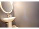 Modern powder room featuring a pedestal sink, elegant mirror, and neutral tones at 1205 Trey Ct, Marietta, GA 30064