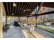 View of the covered outdoor patio showing a dining table, grill, wood storage, and an outdoor ceiling fan at 128 Graybrook Ct, Grayson, GA 30017