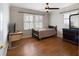 Cozy bedroom with hardwood floors, natural light from bright windows, a ceiling fan, and simple decor at 19 Roving Rd, Cartersville, GA 30121