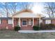 Charming brick home featuring a covered entry way, black shutters, and manicured front yard at 19 Roving Rd, Cartersville, GA 30121