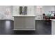 Kitchen island with white countertops and cabinets, complemented by dark hexagon tile floors and stainless appliances at 19 Roving Rd, Cartersville, GA 30121