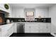 Bright kitchen with white cabinetry, stainless steel appliances, and unique black backsplash at 19 Roving Rd, Cartersville, GA 30121