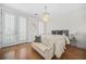 Bright bedroom with hardwood floors, white walls, and a decorative chandelier at 2102 Monhegan Se Way # 2102, Smyrna, GA 30080