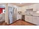 Well-lit kitchen with stainless steel refrigerator and dishwasher and white cabinets at 8720 Rhapsody Ln, Cumming, GA 30041