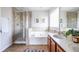 Bathroom featuring a tub, glass shower, and neutral tile at 134 Turman Se Ave, Atlanta, GA 30315