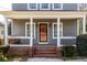 Inviting front porch with brick steps, white columns, and a cozy seating area, perfect for relaxing outdoors at 134 Turman Se Ave, Atlanta, GA 30315