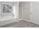 Bathroom featuring a soaking tub, shower, and gray wood floors at 2124 Mitford Ct, Dacula, GA 30019