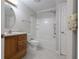 Well-lit bathroom with a wooden vanity and combination tub and shower at 2124 Mitford Ct, Dacula, GA 30019